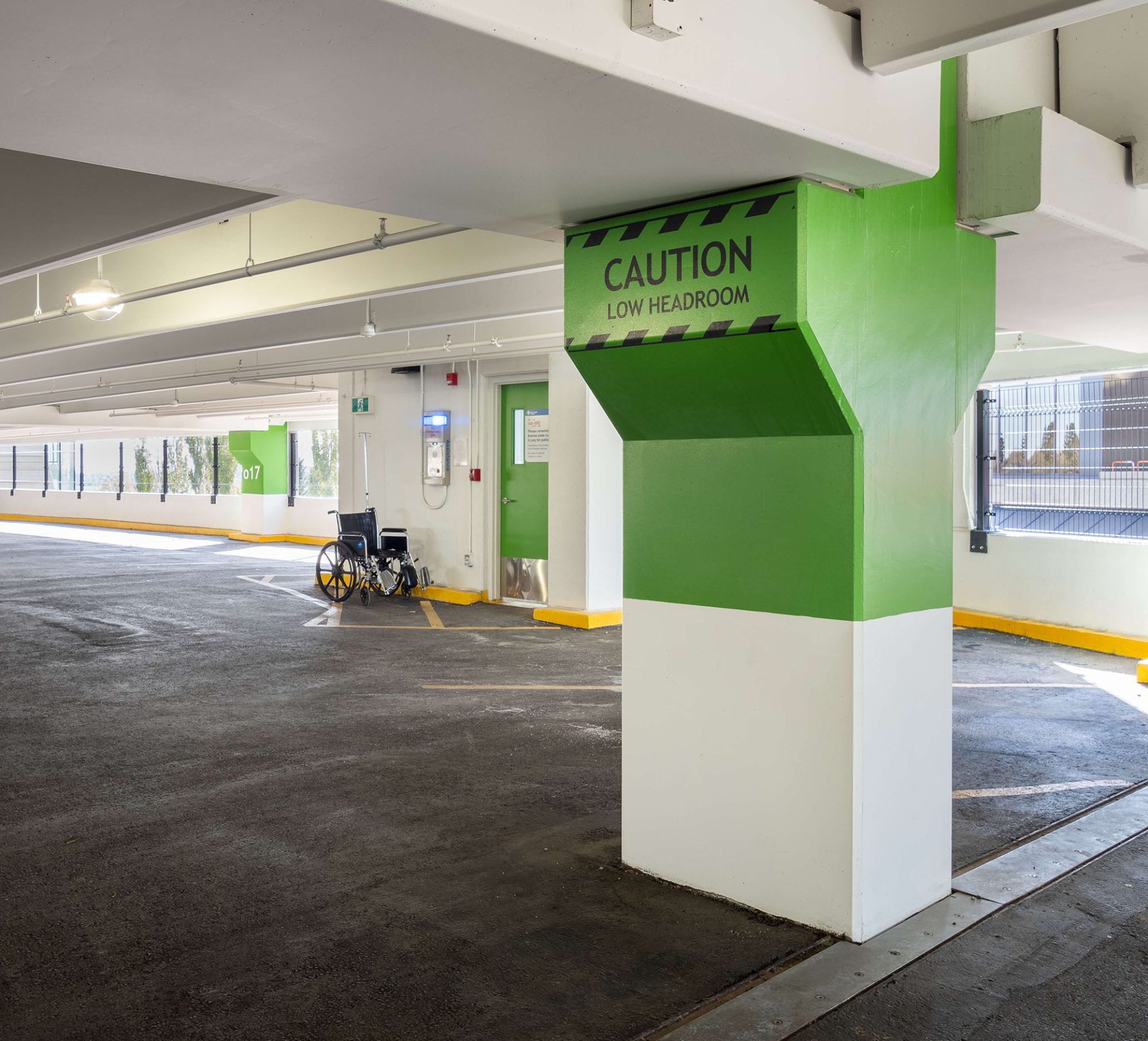 Interior view of the Foothills Medical Centre Parkade with a green pillar containing a painted caution sign